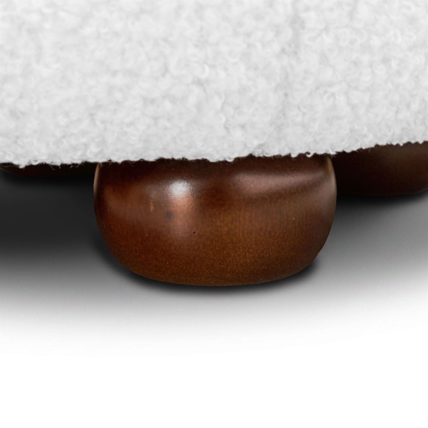 Der Sitzhocker NOLLIE aus Bouclé-Stoff mit dekorativer, segmentierter Form